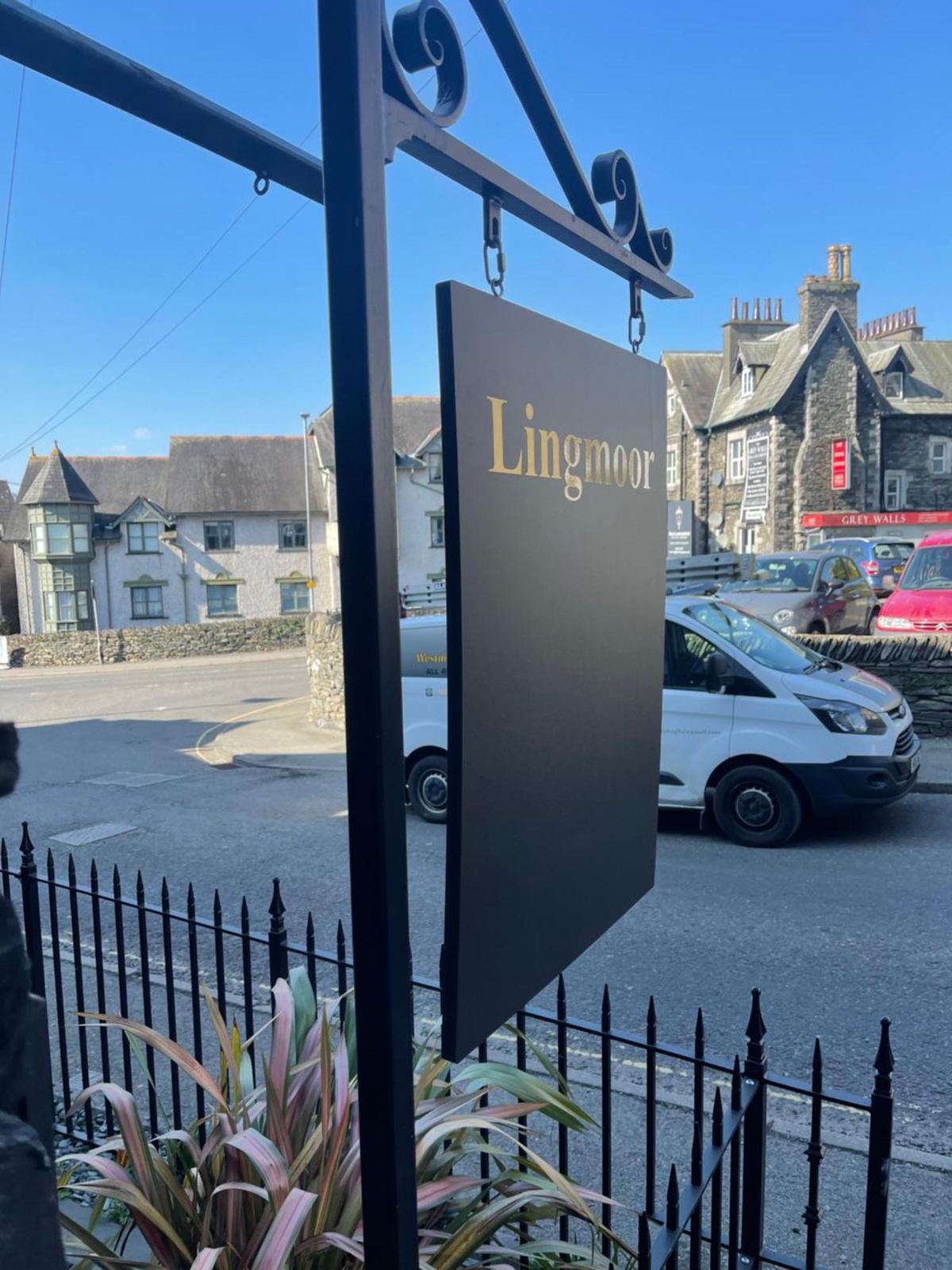 The hanging Lingmoor sign in black with gold lettering, seen against the stone front of the guest house on High Street